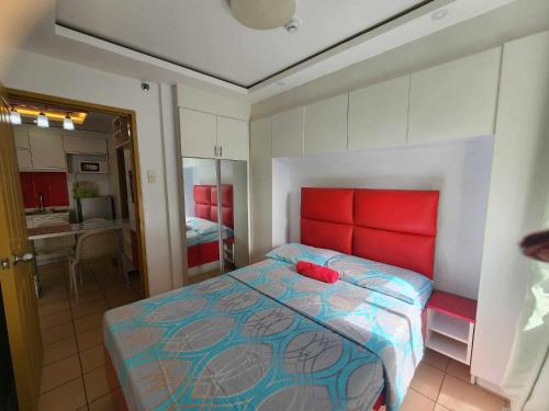 Schlafzimmer mit einem Bett mit rotem Kopfteil in der Unterkunft JFive Homes @ 8Spatial_B2 in Davao City