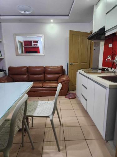 cocina y sala de estar con sofá y mesa en JFive Homes @ 8Spatial_B2 en Dávao