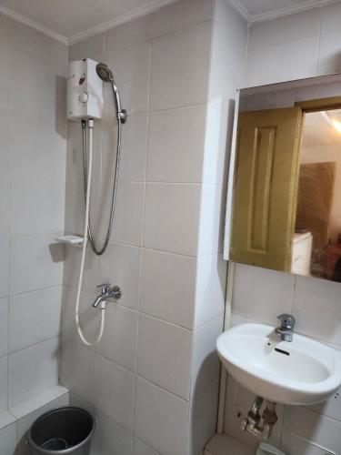 ein weißes Bad mit einem Waschbecken und einer Dusche in der Unterkunft JFive Homes @ 8Spatial_B2 in Davao City