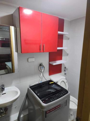 baño pequeño con lavabo y armarios rojos en JFive Homes @ 8Spatial_B2 en Dávao