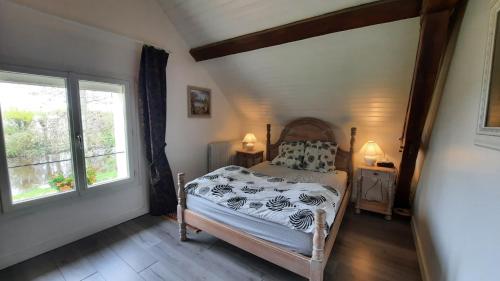 een slaapkamer met een bed en een raam bij etang de la bibardiere in Allonnes
