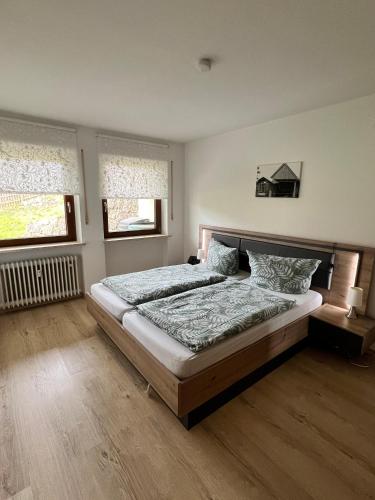 a bedroom with a bed and two windows at Ferienwohnung Strohmeyer in Oberaudorf
