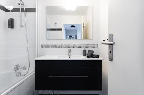 une salle de bain avec un lavabo noir et un miroir dans l'établissement Disney Station, 5 minutes Disneyland!, à Chessy