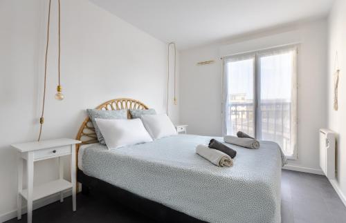 une chambre blanche avec un lit avec des serviettes dessus dans l'établissement Disney Station, 5 minutes Disneyland!, à Chessy