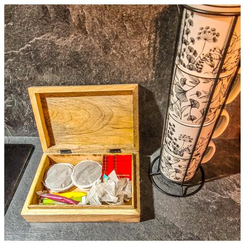 une boîte en bois remplie de divers articles à côté d'un vase dans l'établissement Charme et Confort, à Villeneuve-lès-Béziers