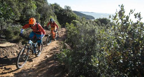 two people riding bikes on a dirt trail at Area Sosta La Pampa in Marina di Grosseto