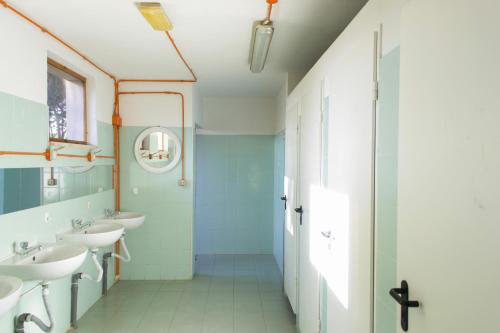 a bathroom with two sinks and two mirrors at Area Sosta La Pampa in Marina di Grosseto