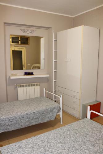a bedroom with two beds and a mirror and a cabinet at La casetta di Rosa - Lentella in Lentella