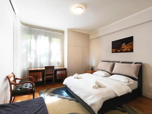 1 dormitorio con 1 cama grande y escritorio en Hestia Anemone - Spacious Apartment in Kolonaki, en Atenas