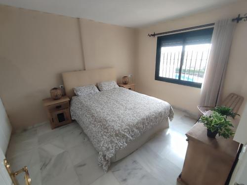une chambre blanche avec un lit et une fenêtre dans l'établissement Pueblo Jardín charming Andalusian complex, à Benalmádena