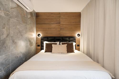 a bedroom with a large bed with a wooden headboard at Mulan Hotel in Tel Aviv