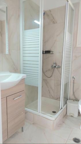 a shower with a glass door in a bathroom at Thanos Guesthouse Corfu in Áyioi Dhéka