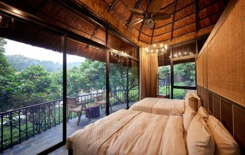 Phúc YênにあるPunna Ecolodge Đại Lảiのベッドルーム1室(ベッド1台、大きな窓付)