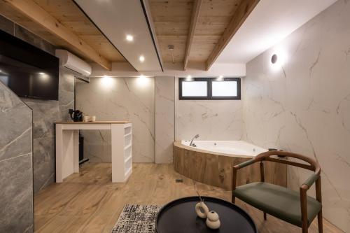 a bathroom with a tub and a chair at Mulan Hotel in Tel Aviv