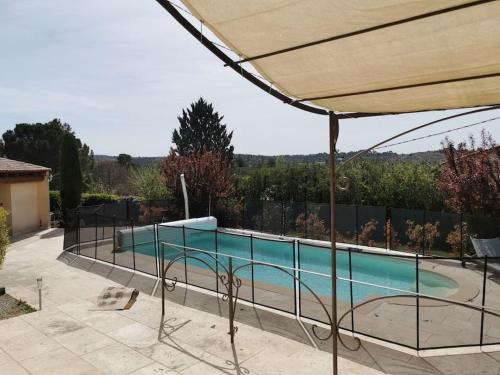a swimming pool in a yard with an umbrella at Villa 7/8p Pierrevert in Pierrevert