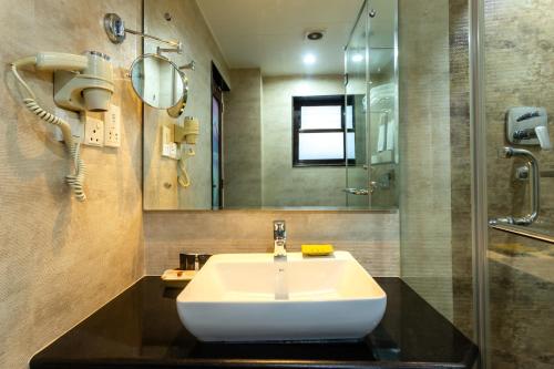 uma casa de banho com um lavatório e um espelho em Hotel Kutumba em Pātan