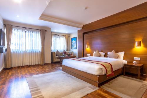 ein Schlafzimmer mit einem großen Bett und einer Holzwand in der Unterkunft Hotel Kutumba in Pātan