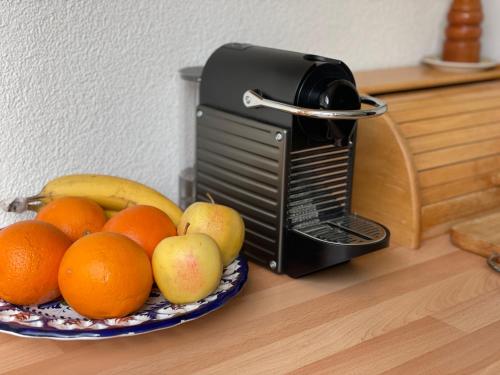a bowl of fruit on a table next to a toaster at Bellevue Apartment in Ringgenberg