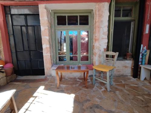 einen Tisch und einen Stuhl vor einem Fenster in der Unterkunft Chania Hostel Youth in Chania