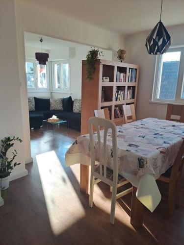 un salon avec une table et des chaises et un salon dans l'établissement Appartement classé 3 étoiles, parking gratuit, proche centre-ville, à Colmar