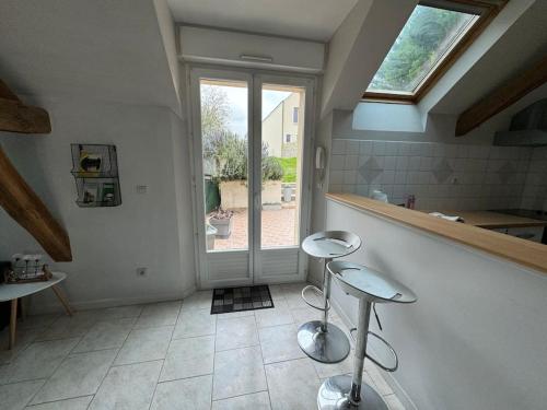 a kitchen with two stools in front of a door at Le Clos de Jade - Maison individuelle - 3 chambres in Nemours