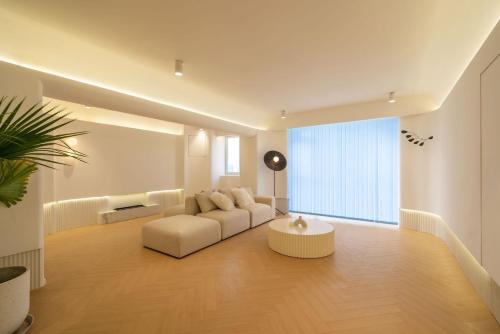 上海Moli B&B - Bund River View Near Yu Garden subway 3bedrooms 2bathrooms 1bathtube with elevator apart ment的客厅里有一张白色的沙发和一张桌子