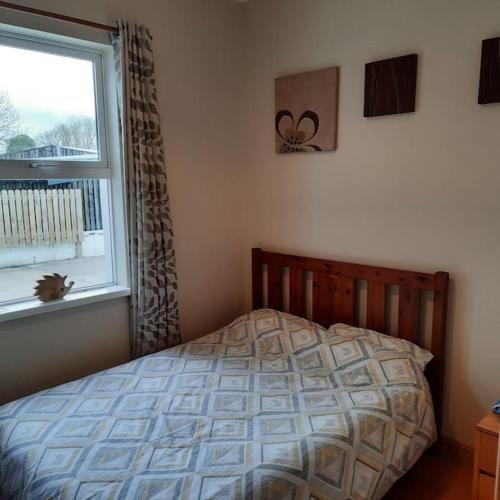 a bedroom with a bed and a window at Cheerful three bedroom country cottage in Ballina