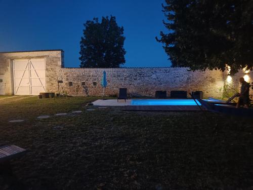 un patio trasero con piscina por la noche en Moulin de Bellicout, en Charmé