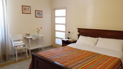 a bedroom with a bed and a table and a window at Casa Cairo Rooms&Services in Mombaroccio