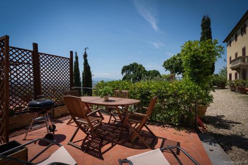 a patio with a table and chairs and a grill at Agriturismo La Gioconda in Vinci