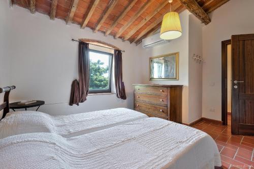 a bedroom with a white bed and a window at Agriturismo La Gioconda in Vinci