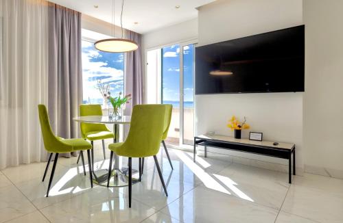 a dining room with a table and green chairs at Apartments & Rooms Grašo in Split