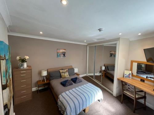 a bedroom with a bed and a desk and a television at Victoria Apartments in Torquay