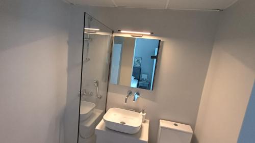 ティノス・タウンにあるTinion Hotelのバスルーム(洗面台、トイレ、鏡付)