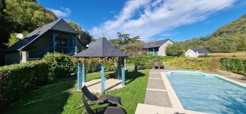 un jardin avec un kiosque à côté d'une piscine dans l'établissement Un moment de partage au Gabizos., à Geu