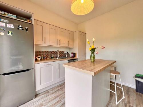a kitchen with a refrigerator and a vase of flowers on a counter at Moate - One Bedroom Self Contained Apartment in Moate