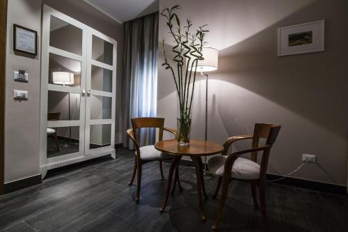 ein Esszimmer mit einem Tisch und Stühlen sowie einer Vase mit Blumen in der Unterkunft Hotel Mediterraneo in Palermo