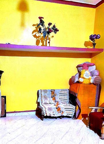 een gele kamer met een stoel en een gele muur bij SHIVAY HOMESTAY in Ayodhya