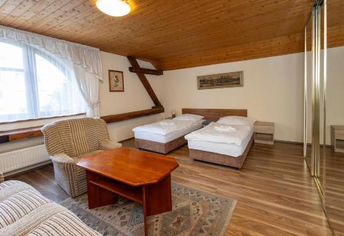 Sala de estar con 2 camas y mesa en Pension Centrum, en Říčany