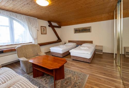 a living room with two beds and a table at Pension Centrum in Ricany