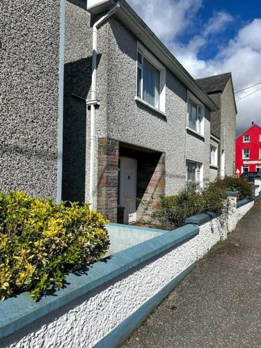 a building with a white door and a red house at Sneem Townhouse in Sneem