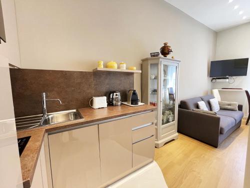 a kitchen with a sink and a couch in a room at Ezevacances Studio Capuccino vue mer 5 mn plage 7 mn gare Wifi in Èze