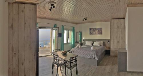 a bedroom with a bed and a table with chairs at Panorama in Armenistis
