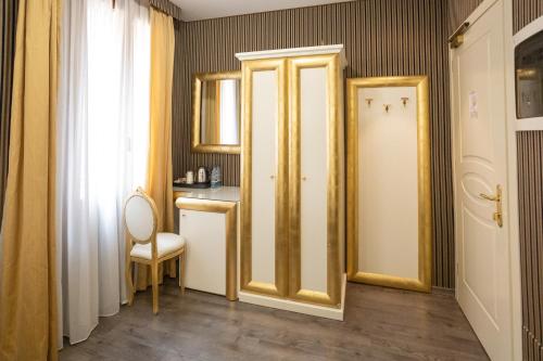 Cette chambre dispose d'une porte, d'une table et d'une chaise. dans l'établissement Duomo Boutique Hotel, à Chioggia