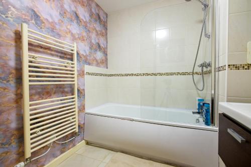 a bathroom with a tub and a shower and a sink at Exclusive Stylish Lodge in Manchester