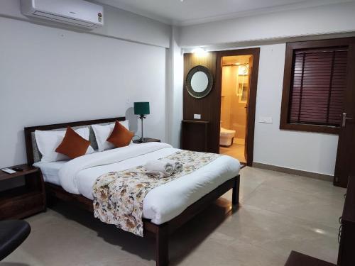 a bedroom with a large bed and a mirror at Aloha Apartments by blissful Ganges in Rishīkesh