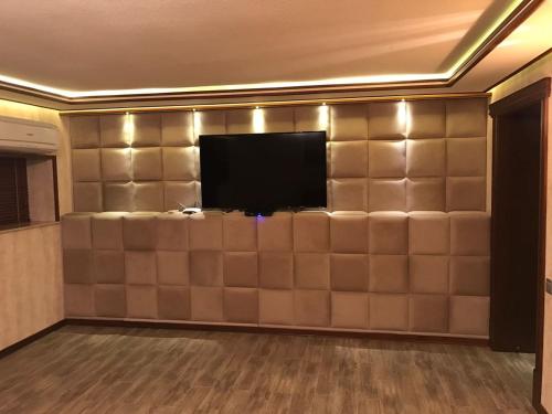een woonkamer met een muur en een flatscreen-tv bij BAKU SAHIL LUX DUPLEX in Baku