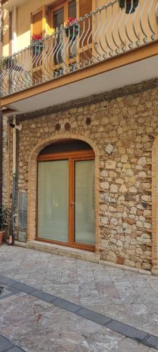 un edificio de ladrillo con balcón y puerta de cristal en Casa DON PEPPE, en Taormina