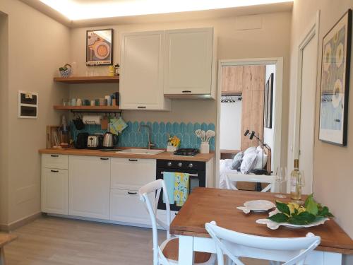 a kitchen with white cabinets and a wooden table at Marty&Olly Luxury Garden Apt in Monterosso al Mare