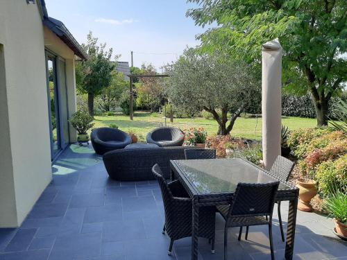 un patio avec une table, des chaises et un canapé dans l'établissement Villa de charme, à Saumur